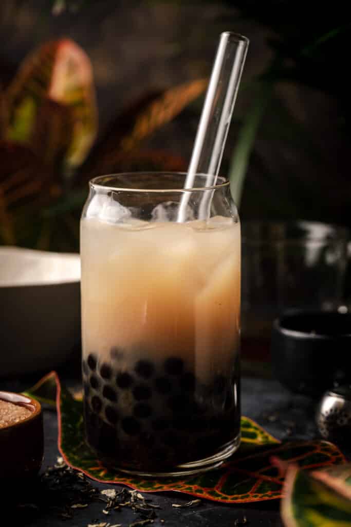 Close up of jasmine bubble tea with a clear glass straw sticking out.