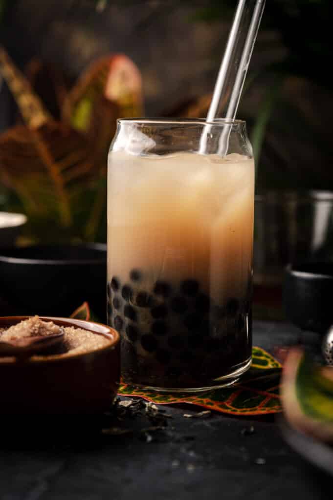 Jasmine boba tea in a Libby glass with a glass tapioca pearl straw sticking out.