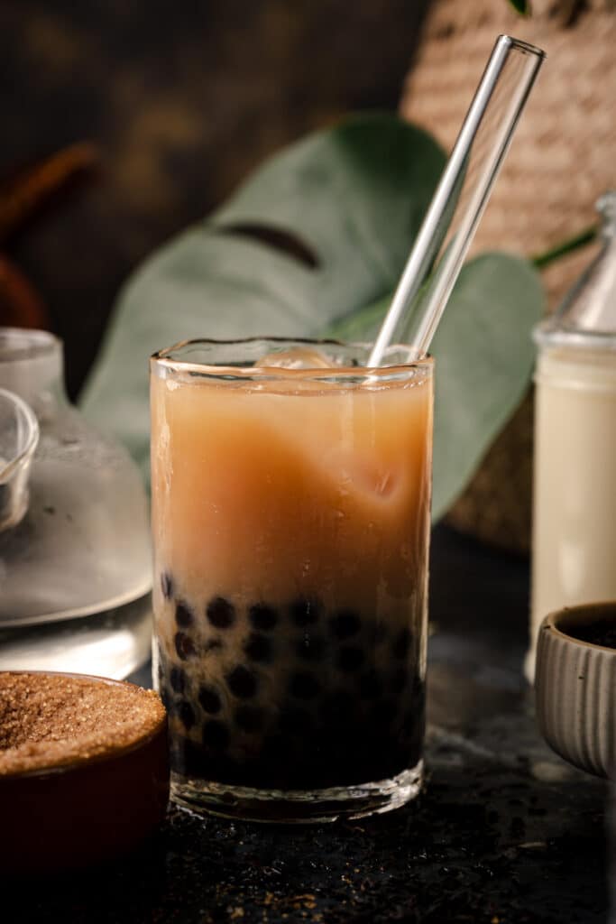 Close up of oolong boba tea with a reusable glass boba straw.