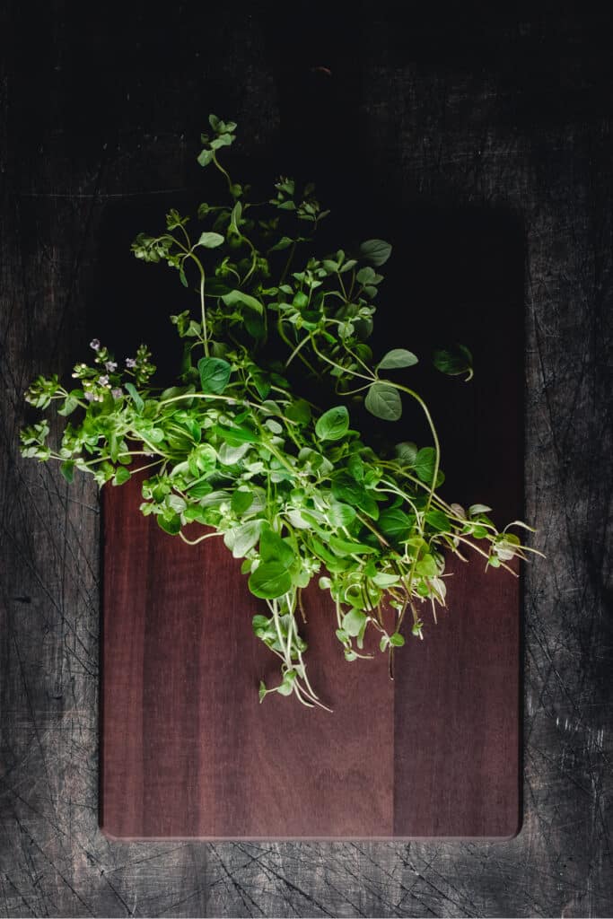 Fresh herbs on a wooden cutting board.