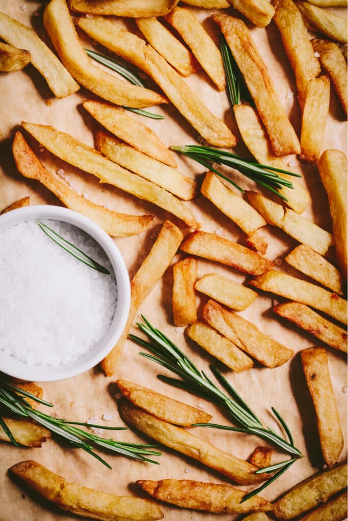 French fries with rosemary sprigs and salt.