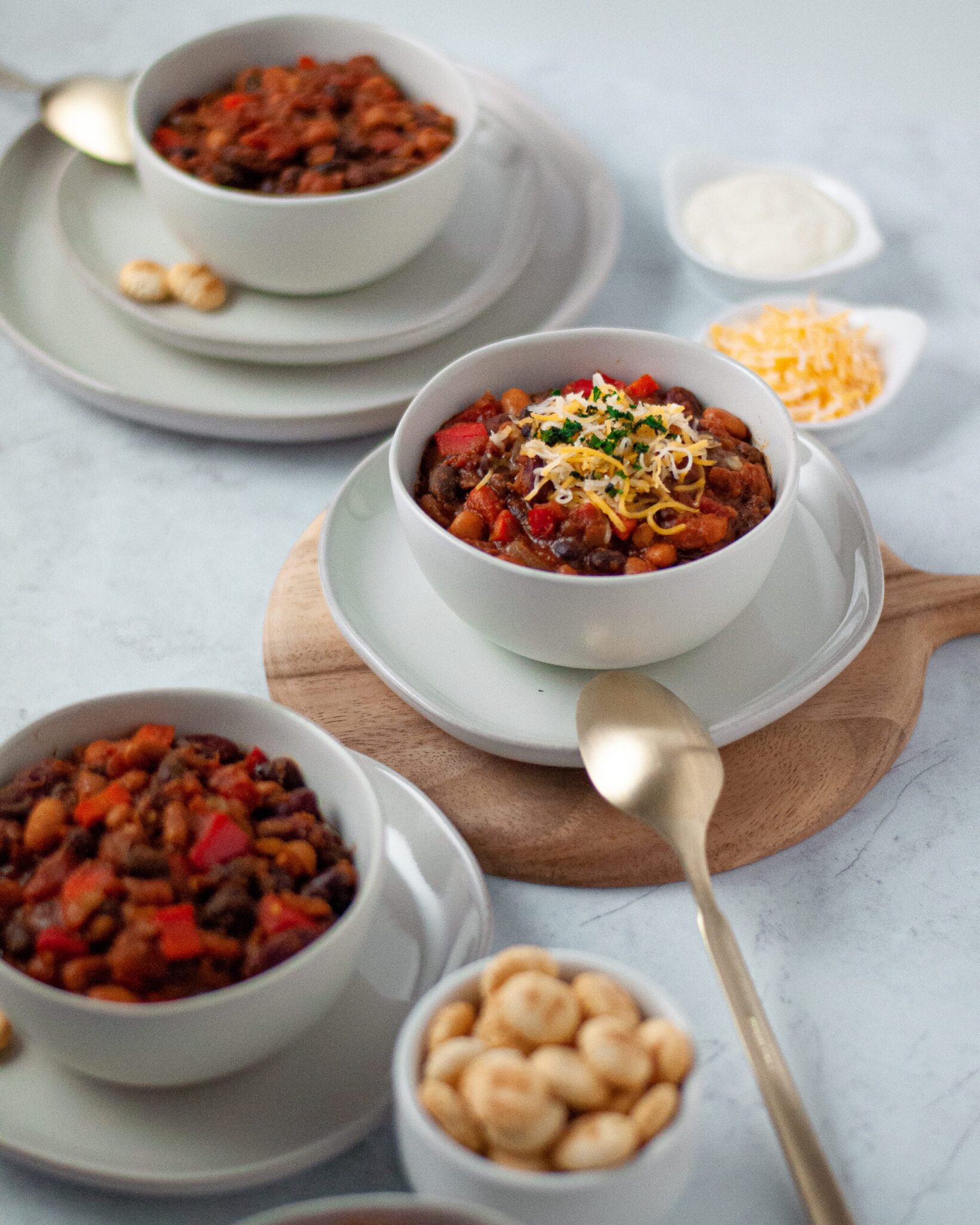Three bowls of chili on a table.