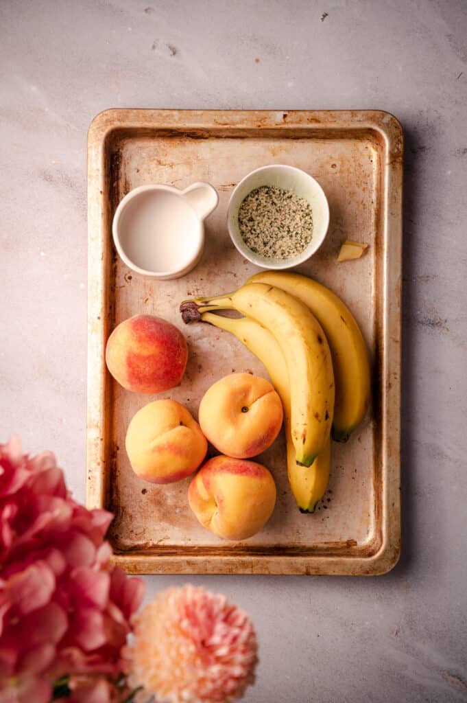 A tray with bananas, peaches, and a bowl of hemp hearts.