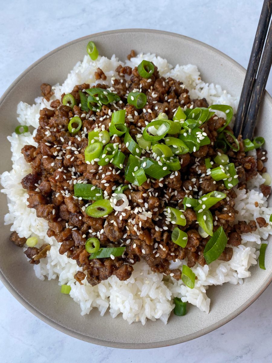 A bowl of beef and rice with sesame seeds.