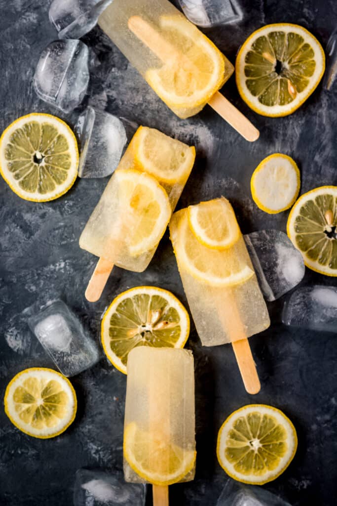 A group of popsicles with lemon slices in them.