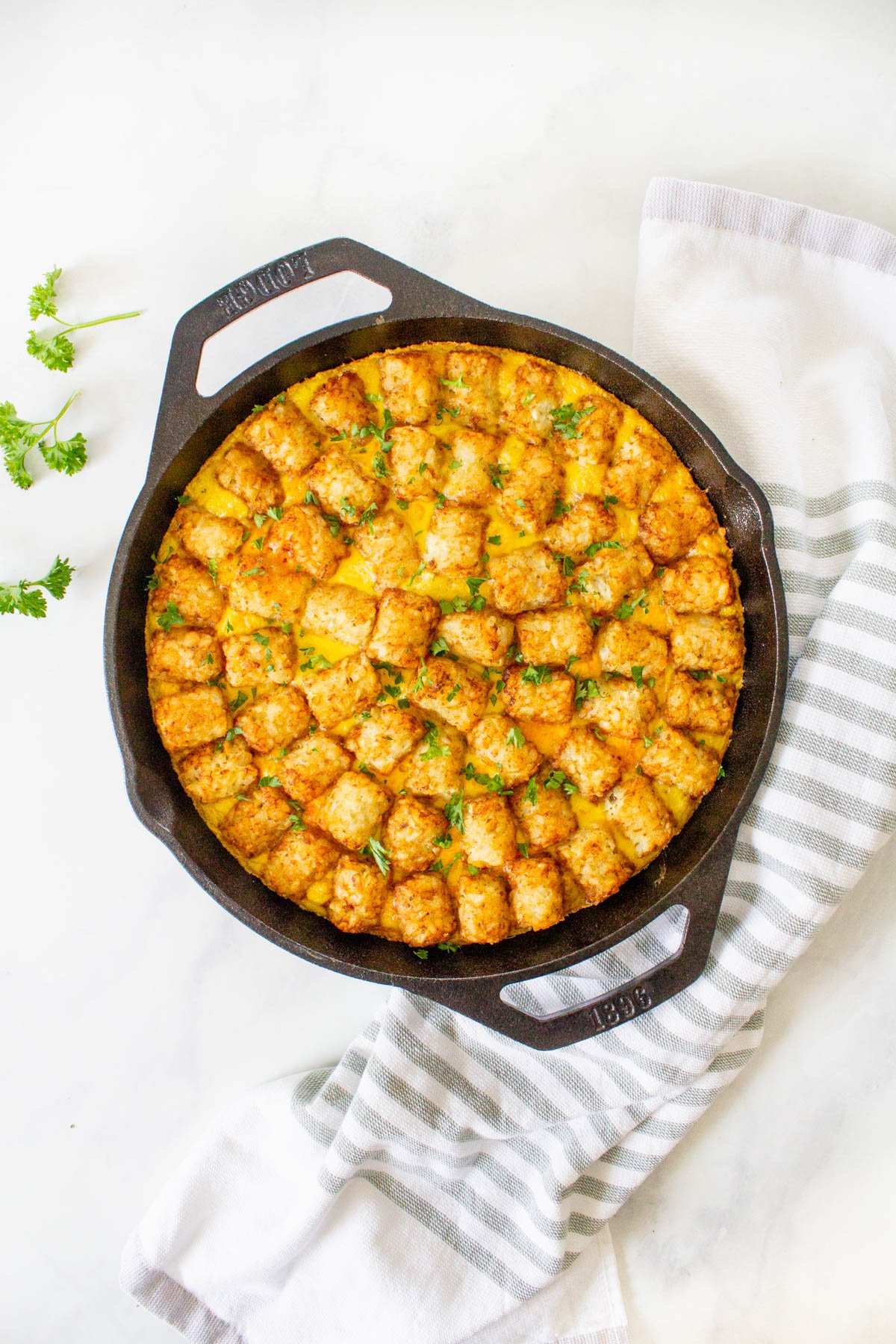 A cast iron skillet with a stuffed tater tot casserole.