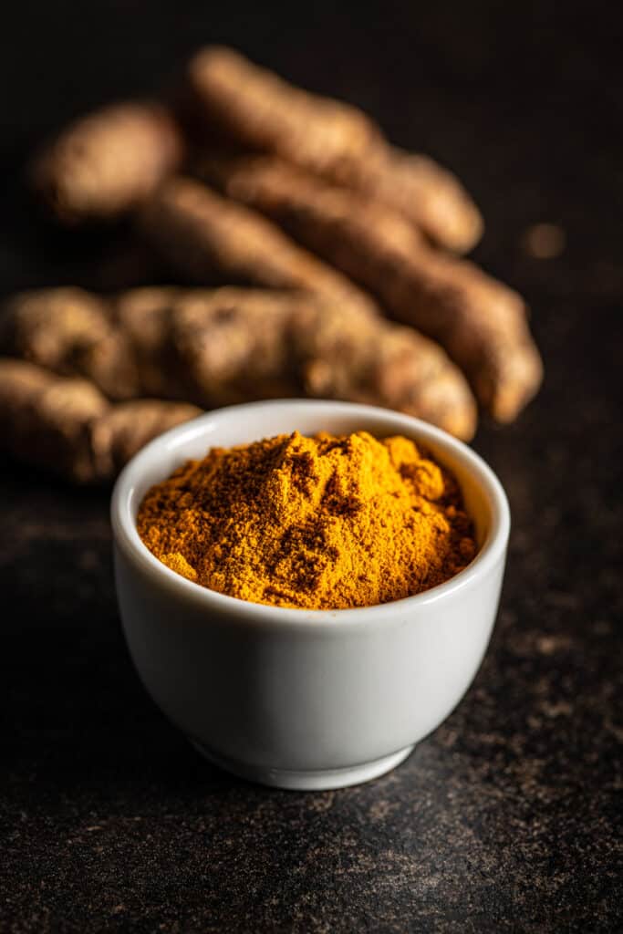 Tumeric powder in a bowl on a table.