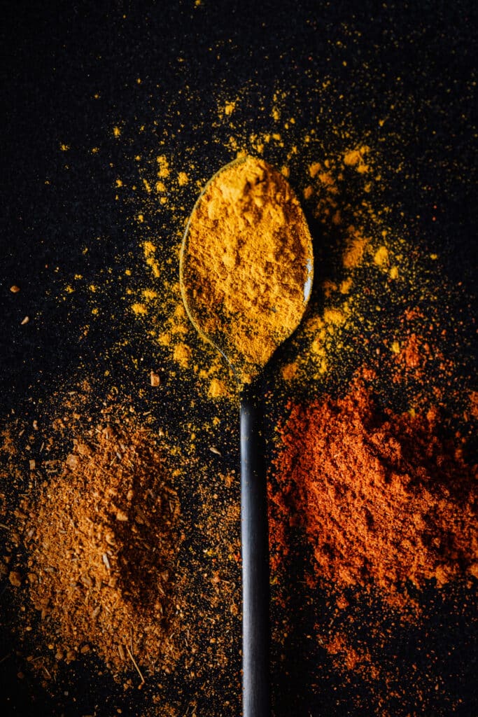 Spices on a spoon on a black background.