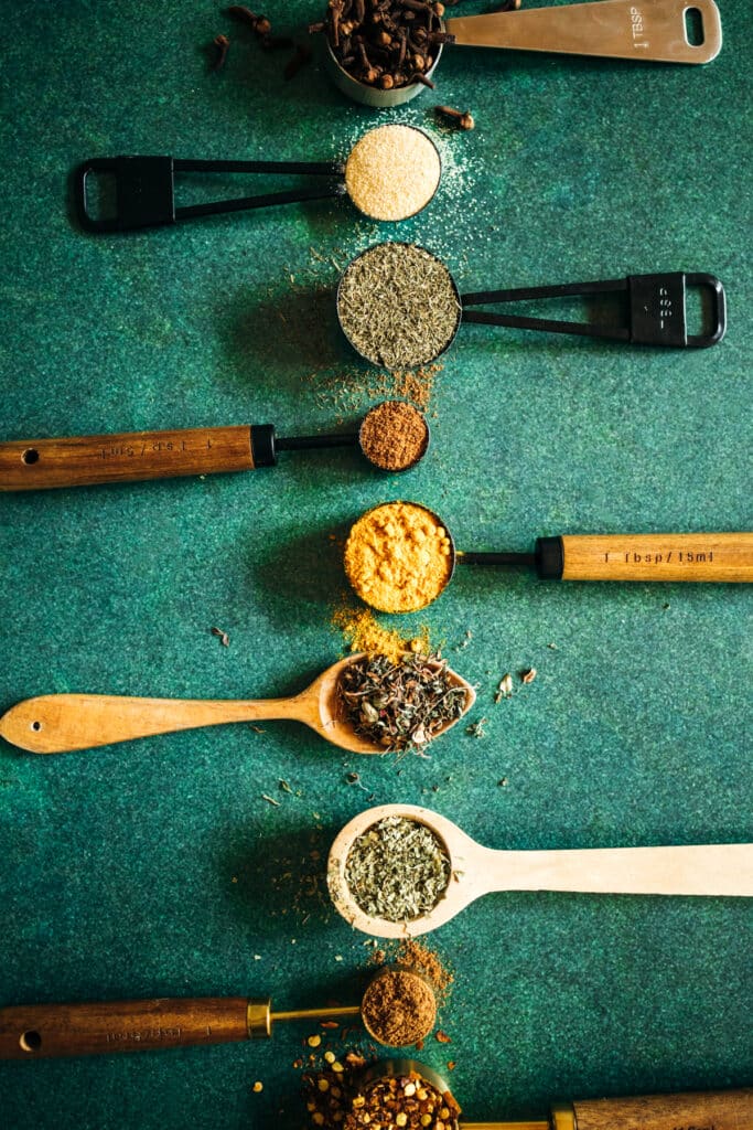 A group of spoons with different spices on them.