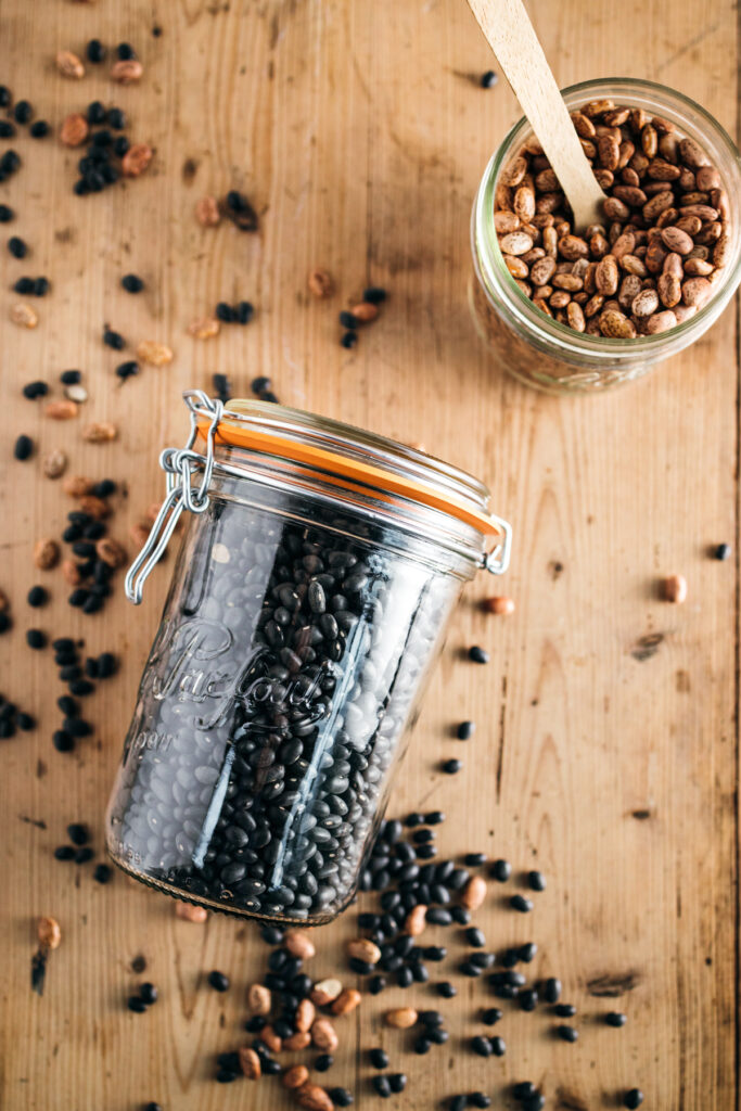 Black beans in a jar on a wooden table.