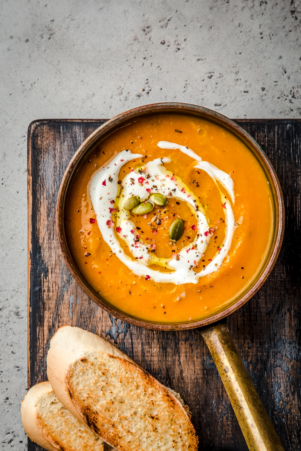 Easy vegan pumpkin curry soup on a wooden cutting board.