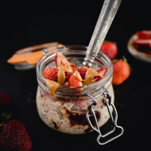 A jar of overnight oats with strawberries and peanut butter.