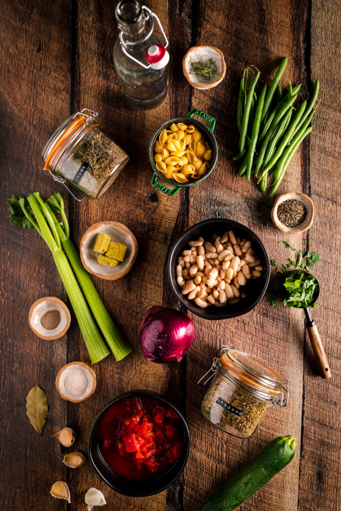 A variety of ingredients are arranged on a wooden table.