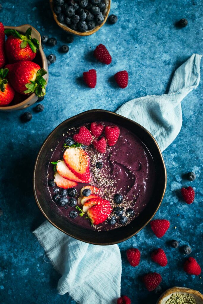 A bowl of acai smoothie with berries and chia seeds.