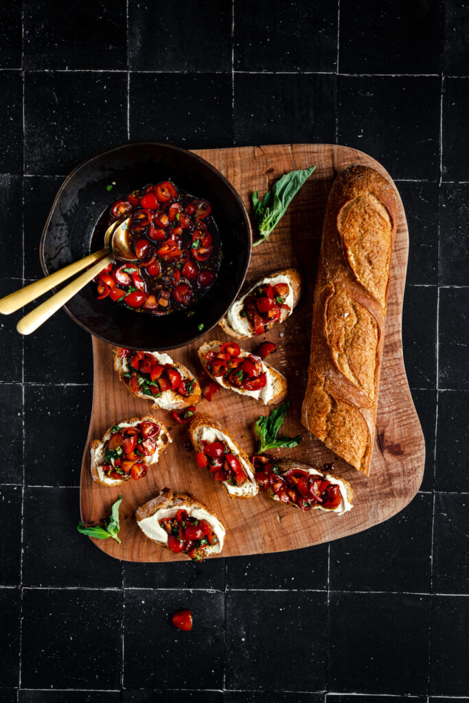 Bruschetta with tomato sauce on a wooden cutting board.