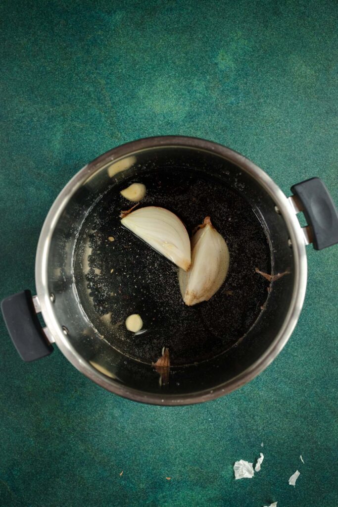 A pan with onions in it on a green surface.