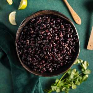 Black beans in a bowl on a green table.