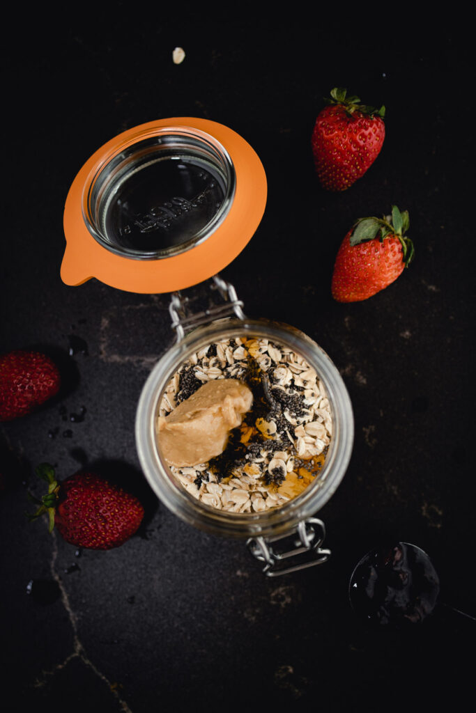 Oatmeal in a jar with strawberries and nuts.