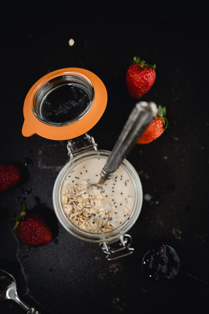 A bowl of overnight oats with strawberries and a spoon.
