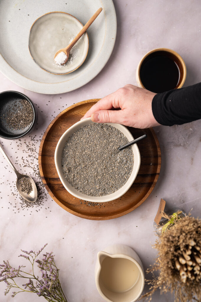 A person pouring chia seeds into a bowl.
