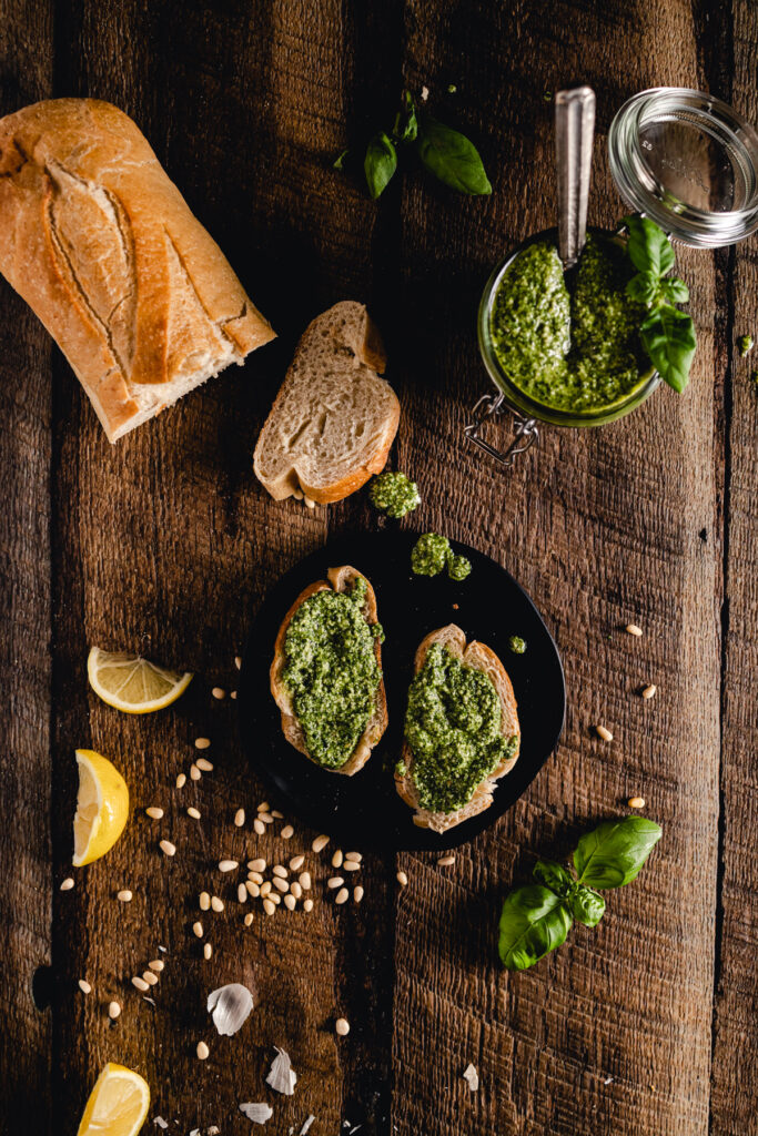 A plate with bread and pesto on a wooden table.