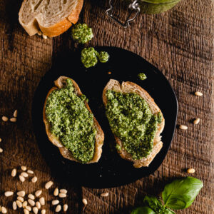 A plate with bread and pesto on it.