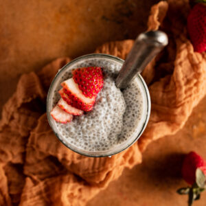 A glass of chia pudding with strawberries.