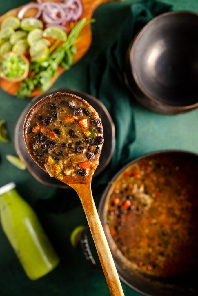 A spoonful of black bean soup on a green table.