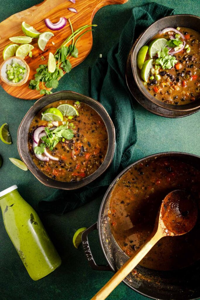 Three bowls of black bean soup on a table.