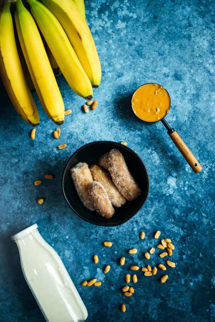 Bananas, peanuts and a bottle of milk on a blue background.