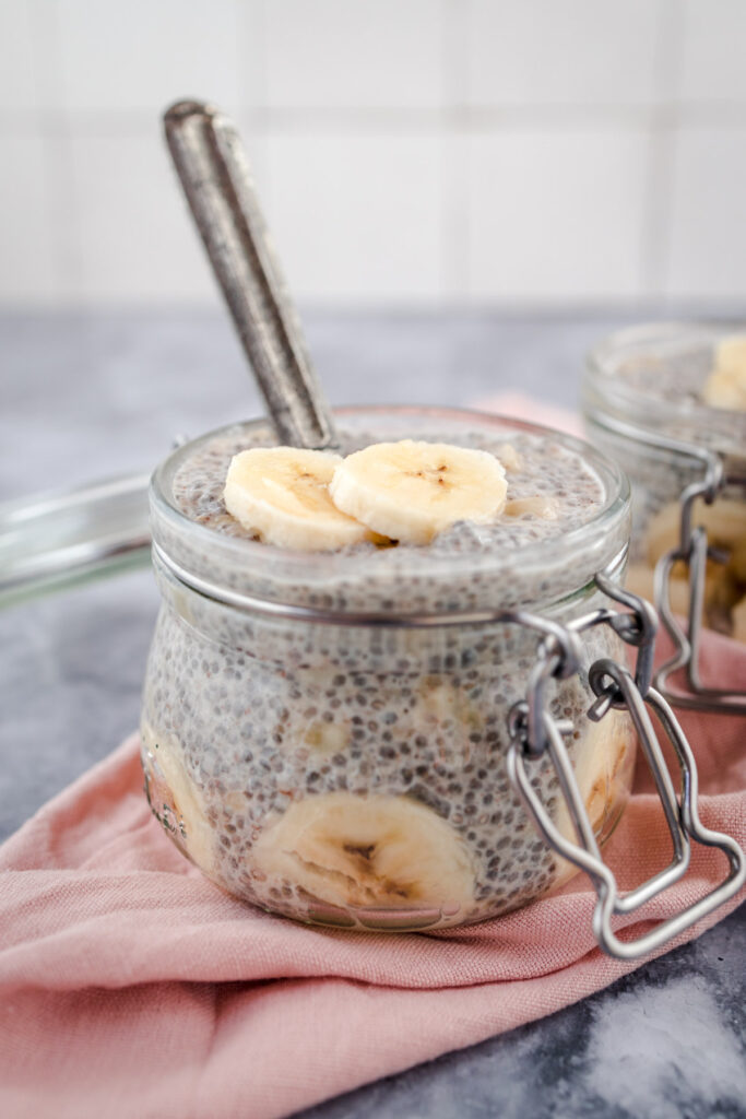 A jar of chia pudding topped with banana slices.