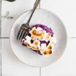 Vegan sweet potato casserole on a white plate with an antique fork.