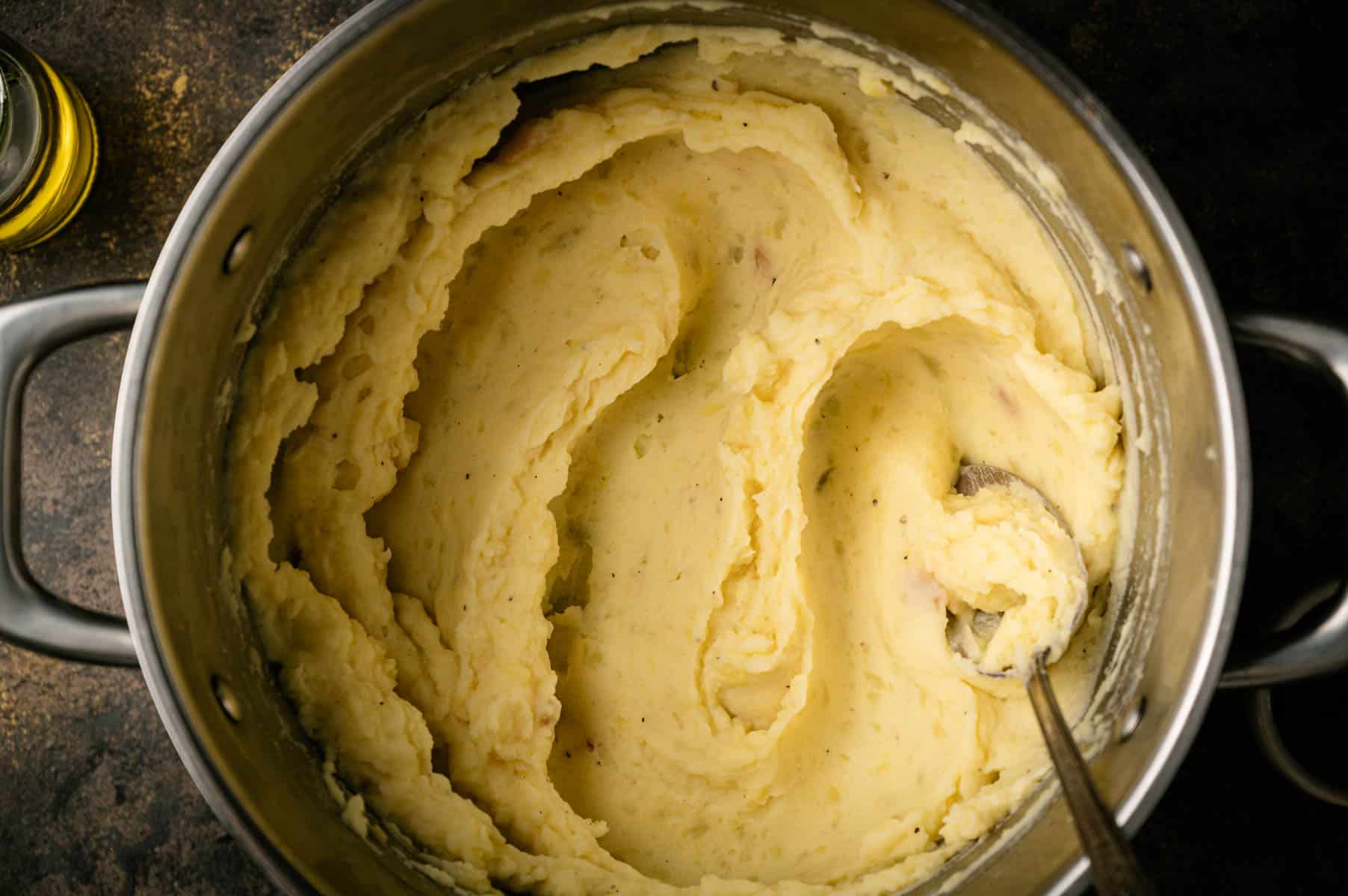 Nut milk mashed potatoes smoothed out in a cooking pot.