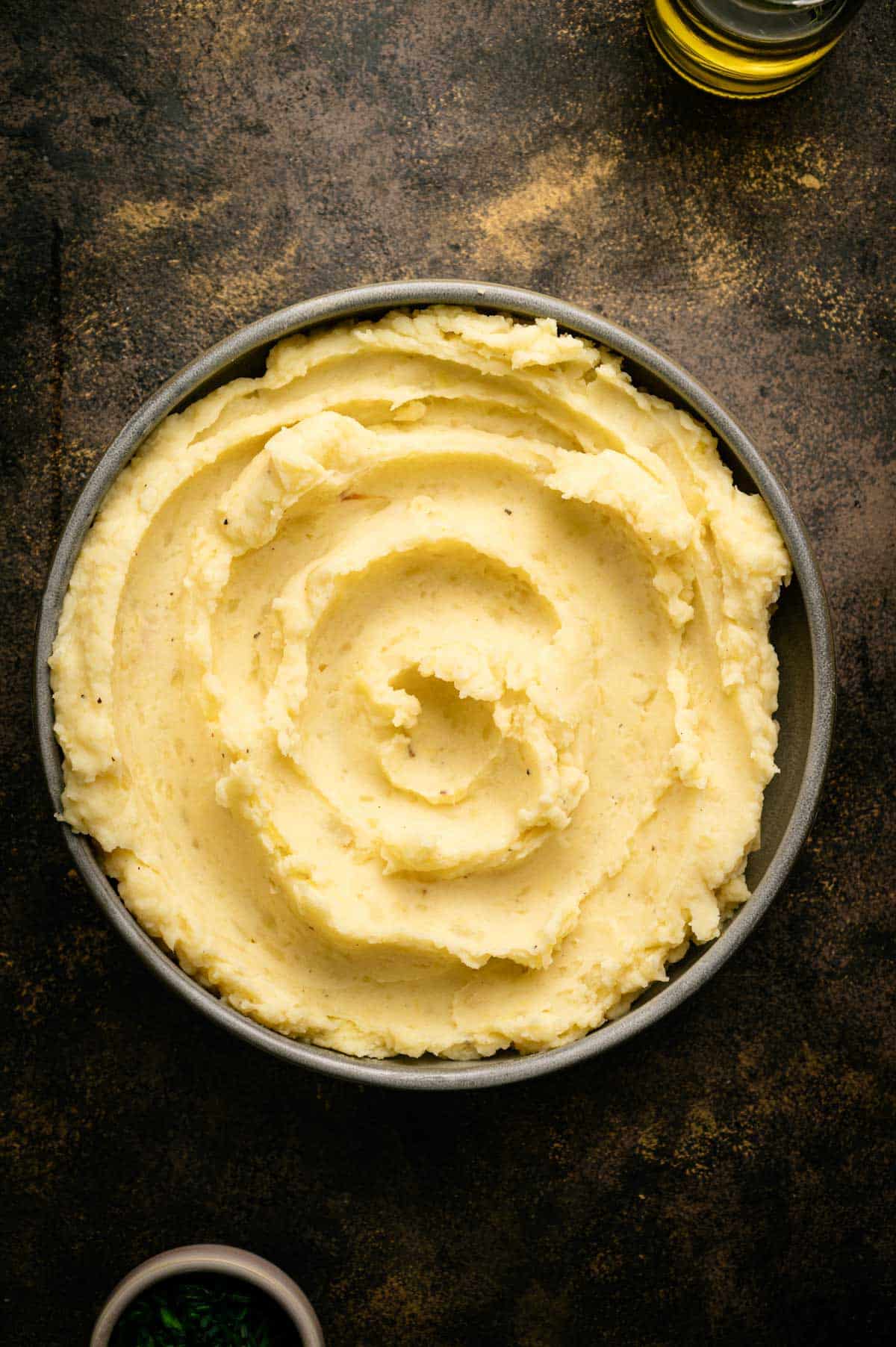 Mashed potatoes smoothed out in a shallow bowl.