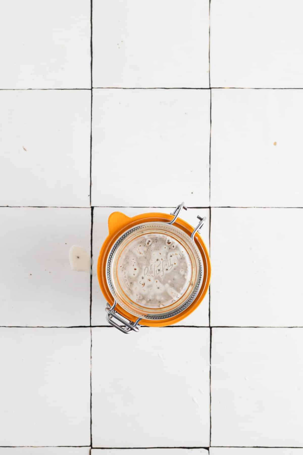 Flax seed and chia seed pudding in a clear glass jar with a rubber seal.