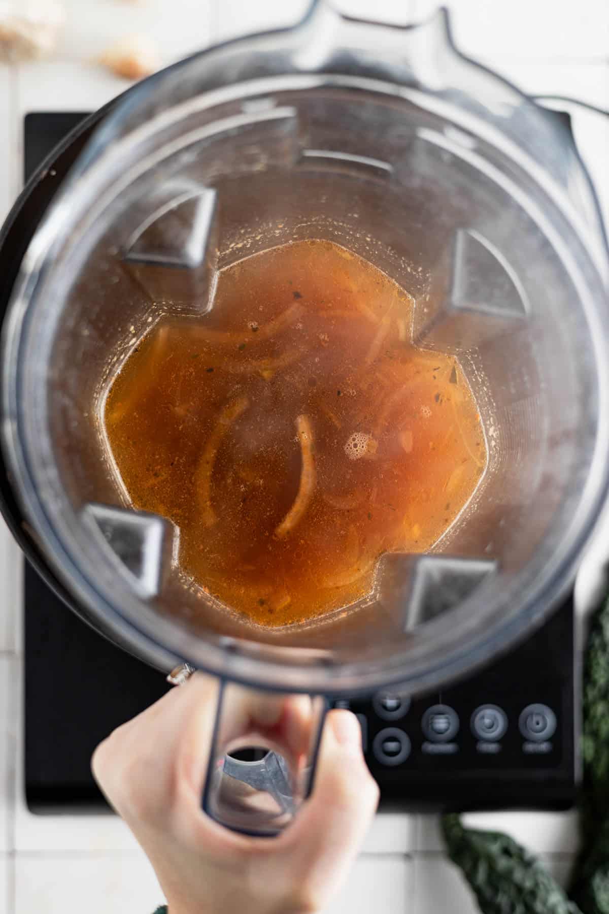 Half of the soup added to a blender to puree.