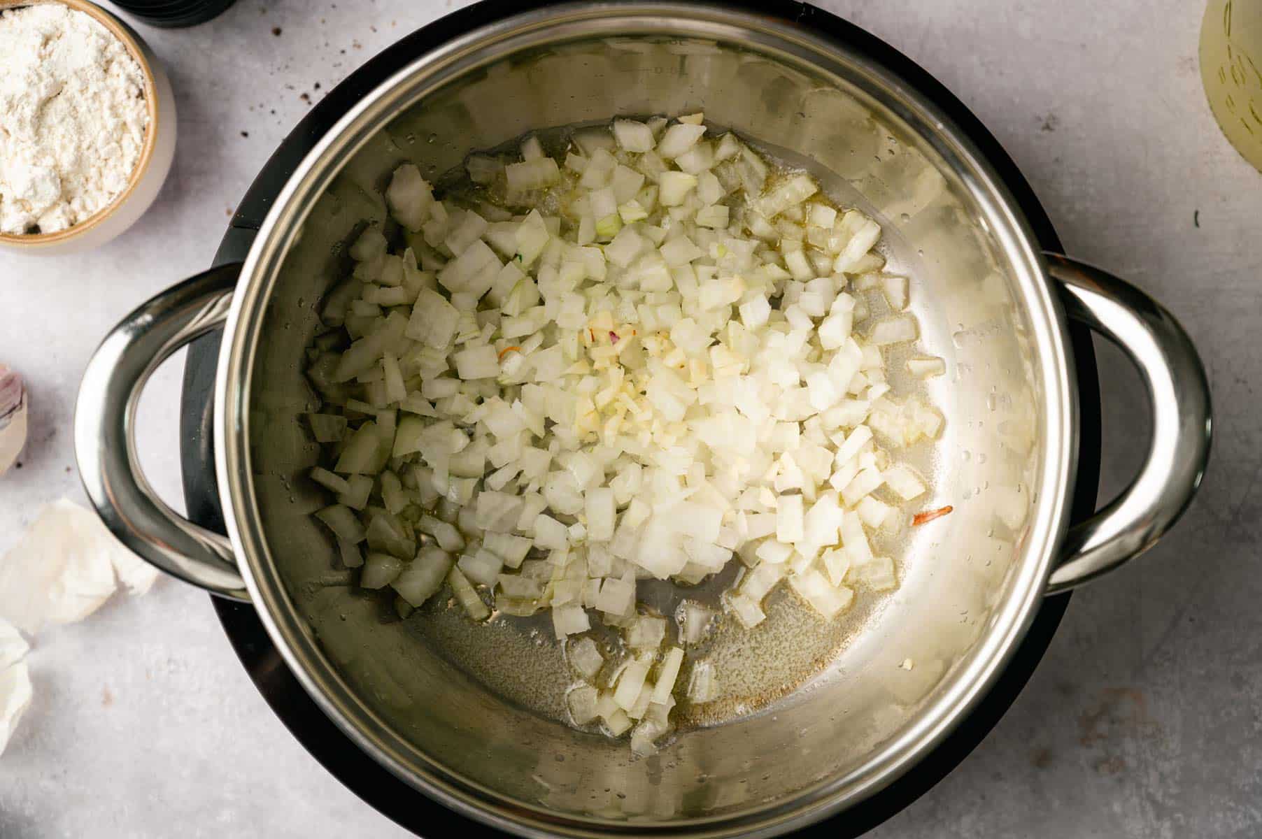Diced onions sautéing in a cooking pot.