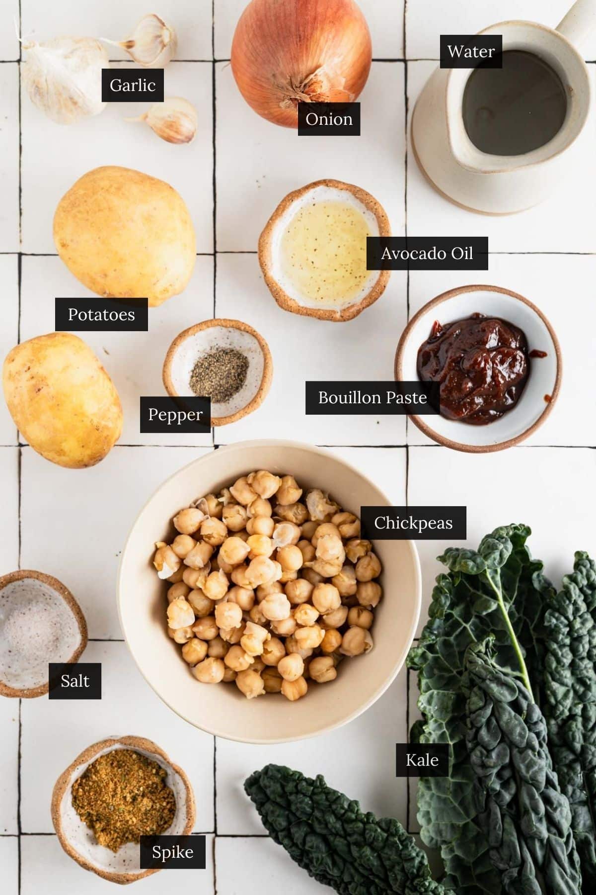 Ingredients for kale chickpea potato soup on white tile.
