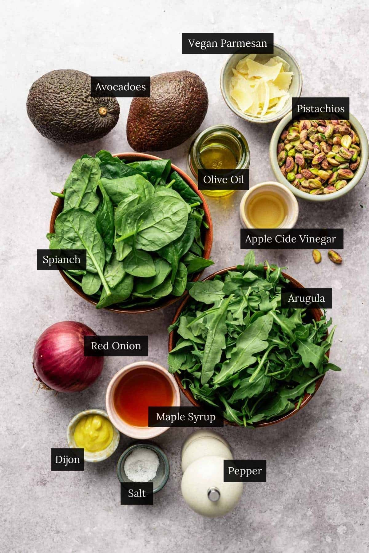Ingredients for spinach and arugula salad with maple Dijon vinaigrette with each ingredient labeled.