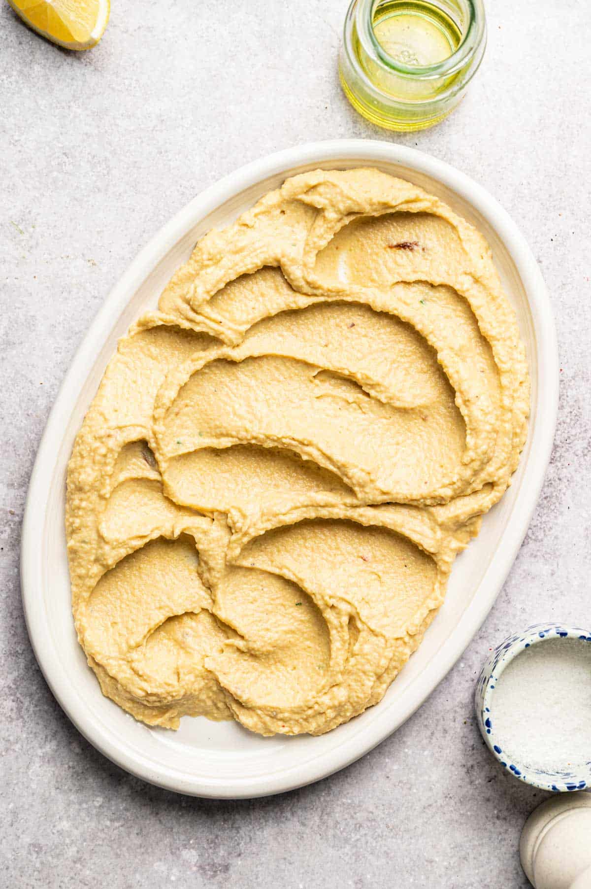 Homemade hummus spread out on a serving platter.
