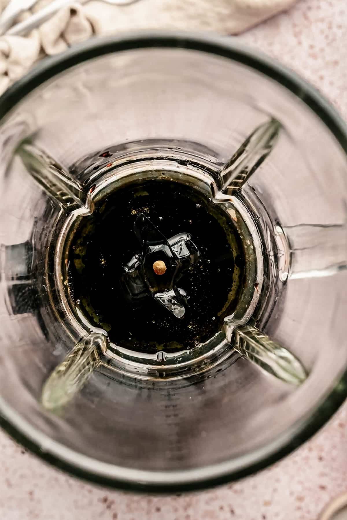 Adding oil and balsamic vinegar to a blender.