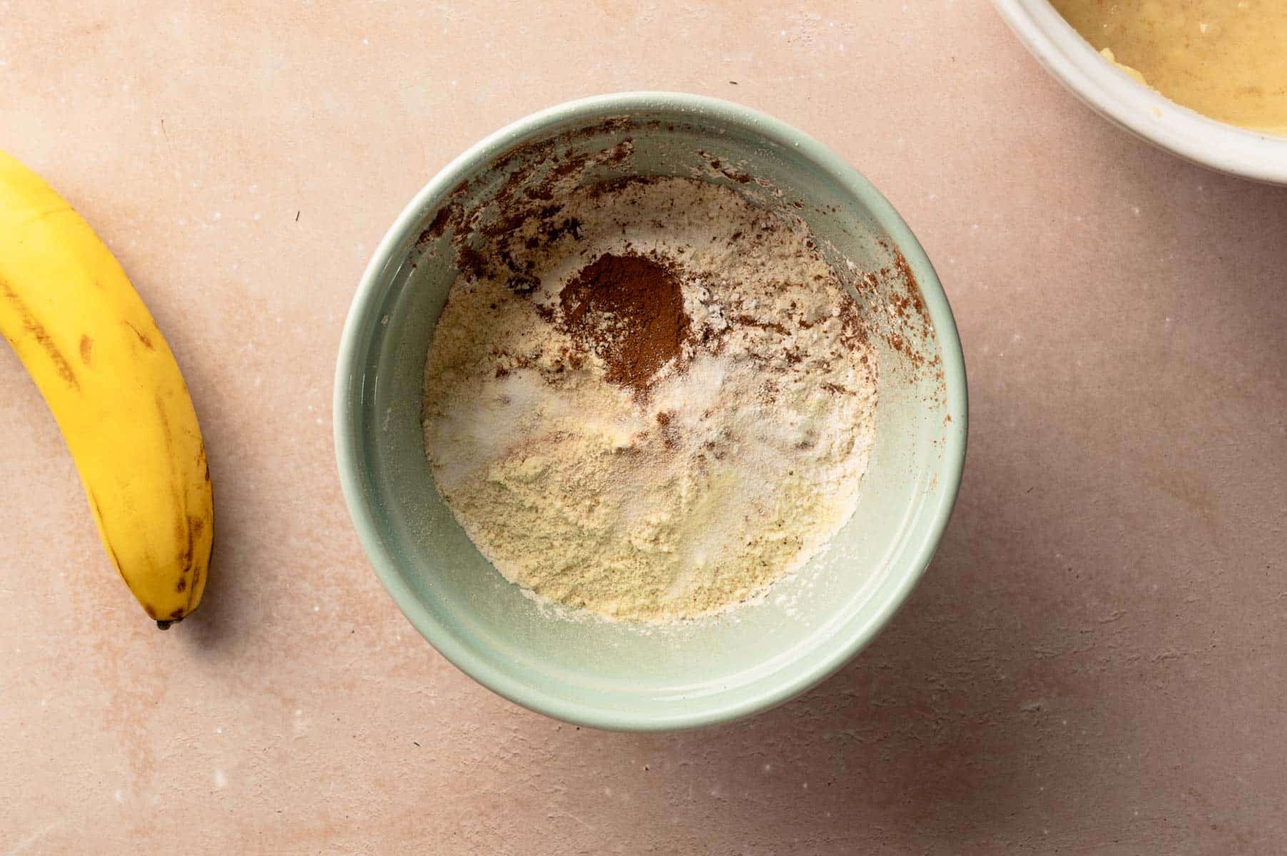 Dry ingredients for homemade high protein muffins in a sea green mixing bowl.