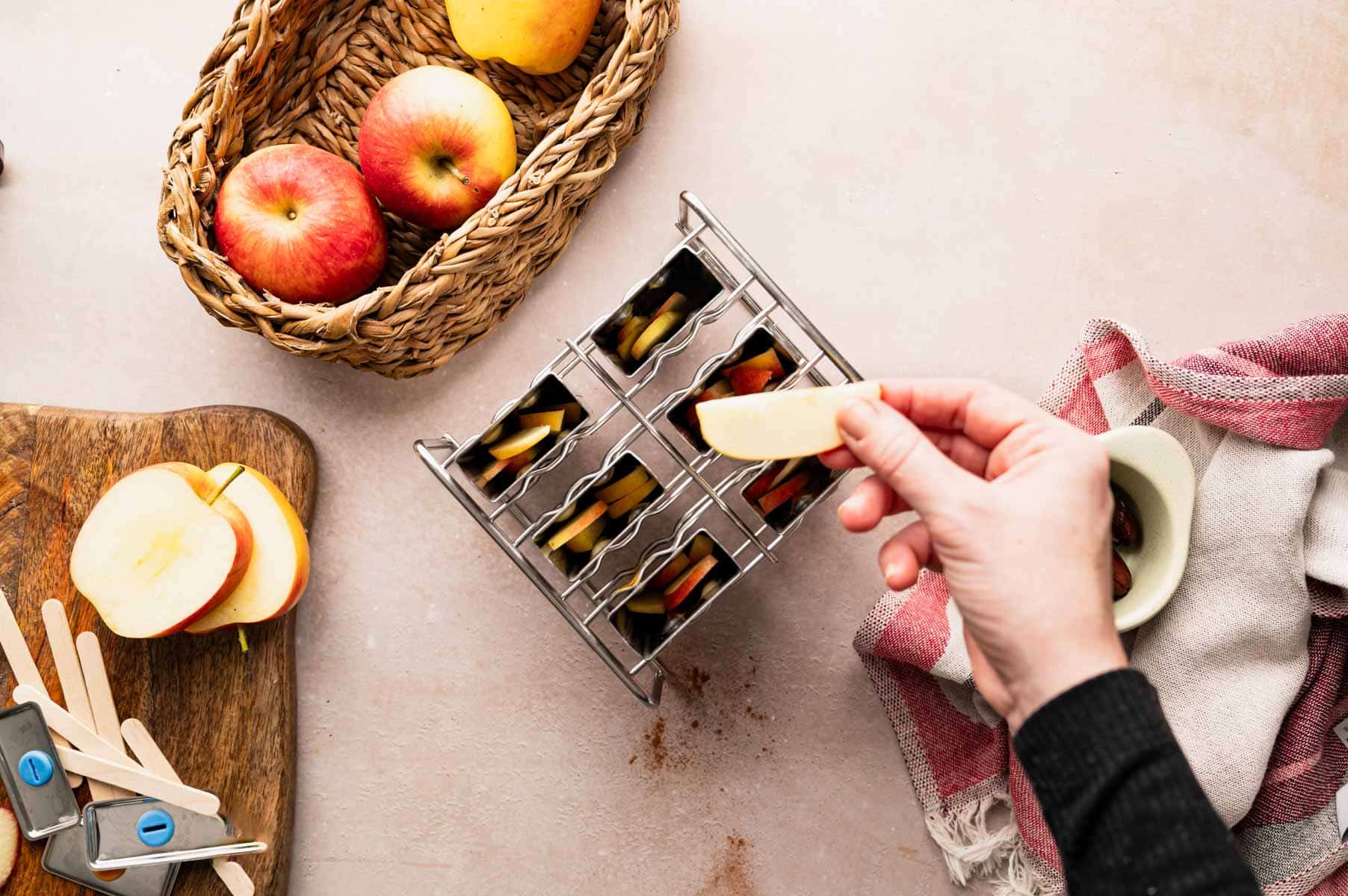Adding apples to popsicles mold.