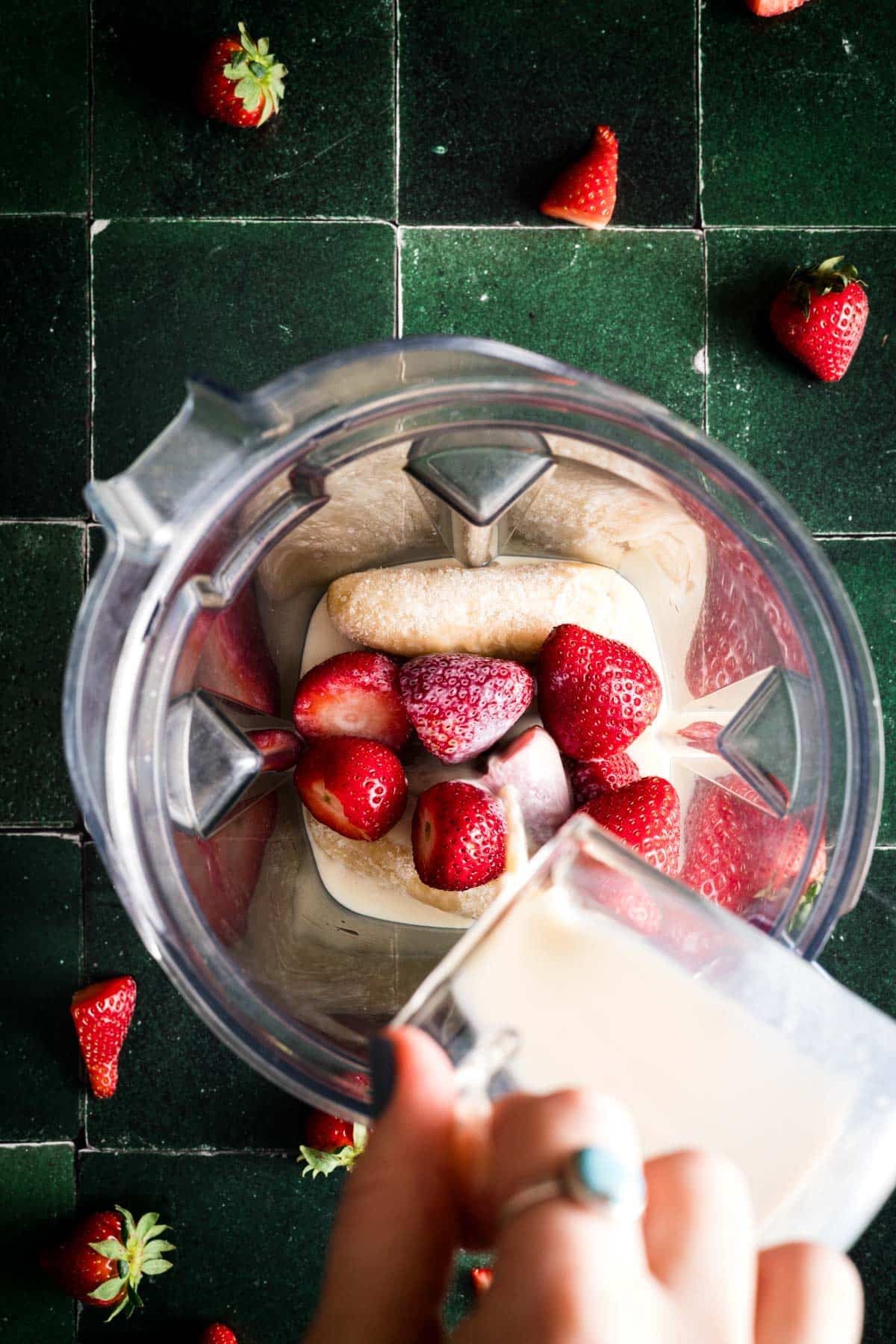 Ingredients for strawberry and banana smoothie in a blender without yogurt.