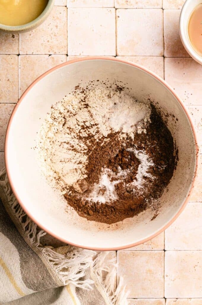 Dry ingredients for vegan chocolate muffins in a mixing bowl.