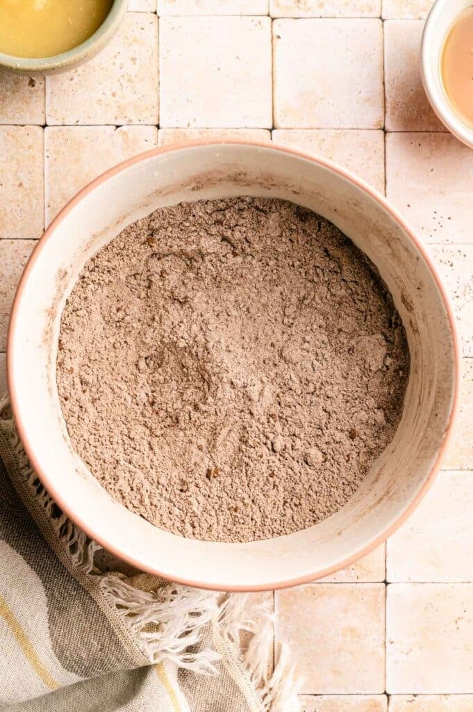 Dry ingredients for vegan chocolate muffins in a mixing bowl.