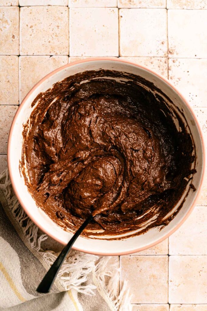 Chocolate chips added to chocolate muffins batter and mixed together.