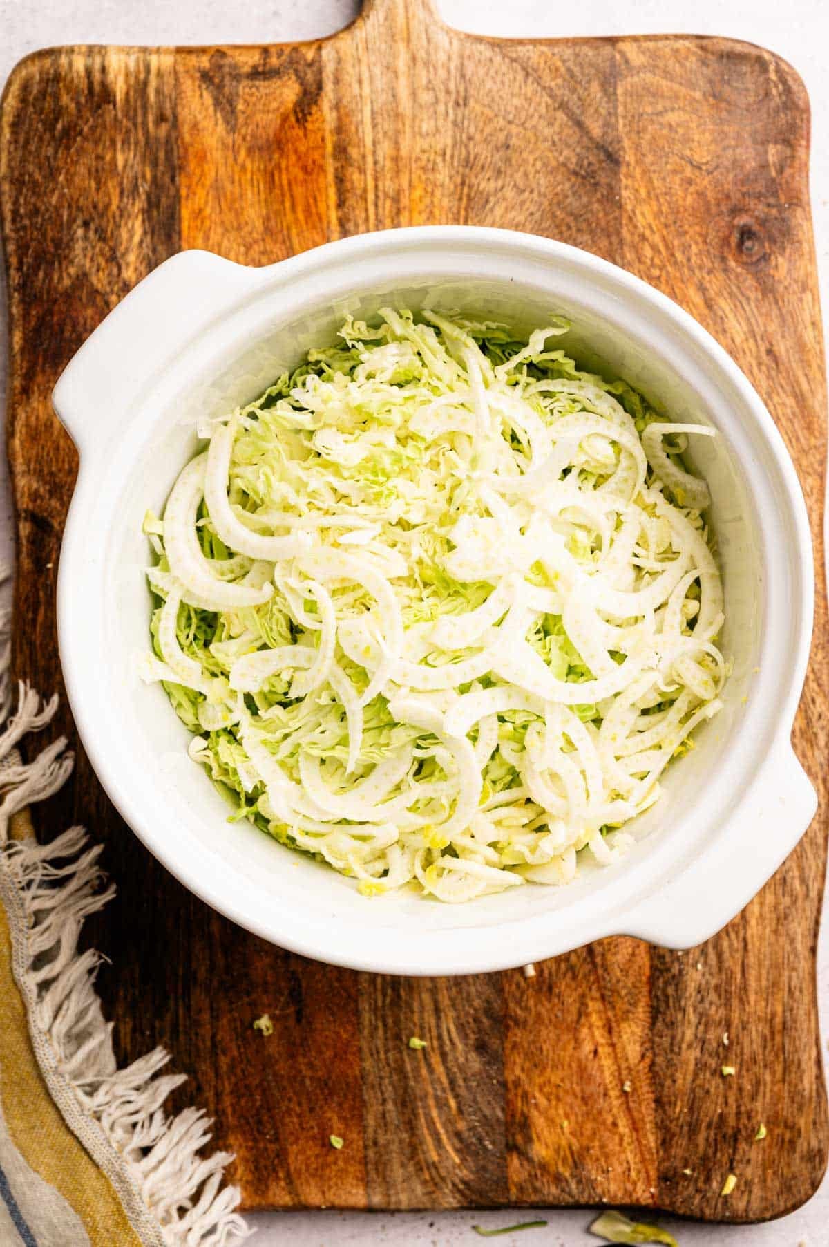 Finely shredded cabbage and fennel in a large mixing bowl.