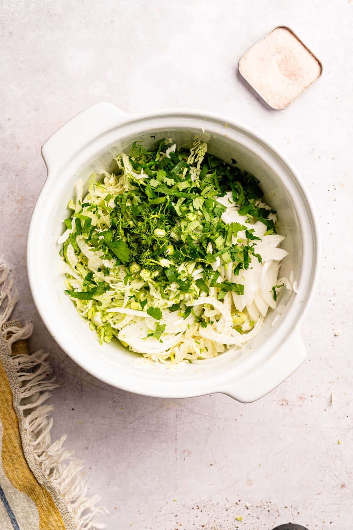 All the ingredients for shredded cabbage salad in a white mixing bowl.