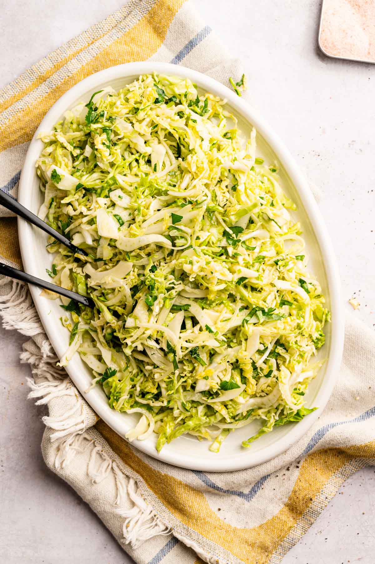 Crunchy cabbage salad on an oval serving plate.